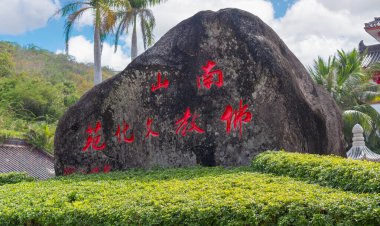 China, Hainan island, Sanya - January 21, 2020: Grand stone with red hieroglyphs near entrance gate to the Nanshan Buddhism Cultural Zone. A popular attraction among tourists and believers clipart