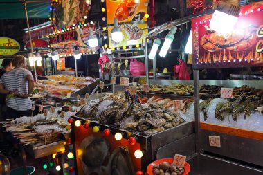 Kuala Lumpur, Malezya - 15 Mart 2019: Jalan Alor 'da deniz ürünleri büfesi. Kuala Lumpur 'da gece yemekleri sokağı. Popüler turist eğlencesi. Seçici odak, gece düşük ışıkta çekilmiş fotoğraf