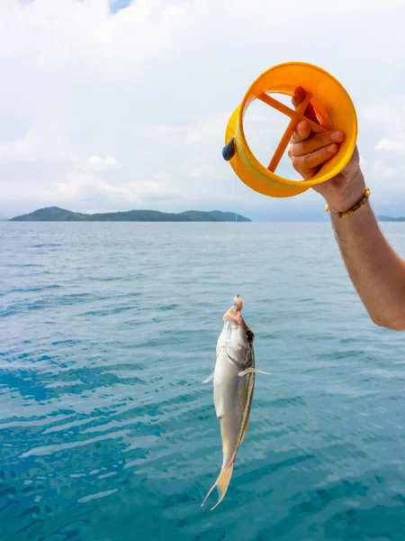 釣り人は引っかかった魚を持っている アジアのボートボードからの熱帯海釣り — ストック写真