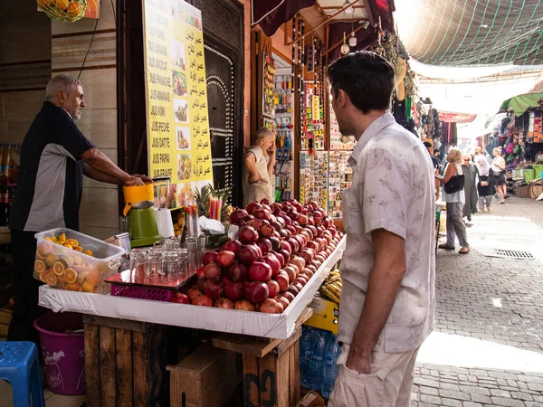 Marakeş, Fas - 13 Ekim 2019: Marakeş Medine 'de Avrupalı turist ve taze meyve suyu satıcısı