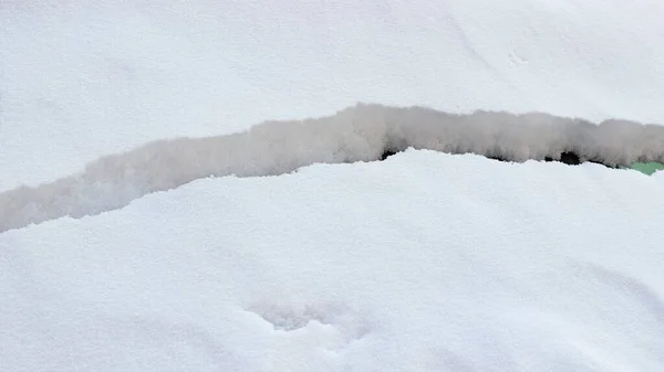 ふわふわの白い雪の表面に広い亀裂 雪崩の危険性 — ストック写真