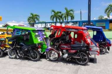 Tagbilaran, Filipinler - 30 Eylül 2018: Tagbilaran, Bohol Adası 'na yolcu bekleyen üç tekerlekli motosiklet taksileri.