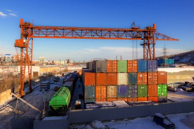 Krasnoyarsk, Rusya - 9 Şubat 2021: Kargo konteynırları ve gantry vinç ile demiryolu deposu. Genel amaç 12 metrelik konteynırlar. Sanayi geçmişi