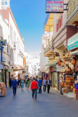 Tanca, Fas - 17 Ekim 2019: Hediyelik eşya dükkanları ve Fas Medine 'de yürüyen insanlarla dolu otantik cadde