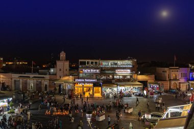 Marakeş, Fas - 12 Ekim 2019: Marakeş, Fas 'ta gece Jemaa el-Fna meydanında sokak satıcıları ve turistler. Düşük ışık atışı