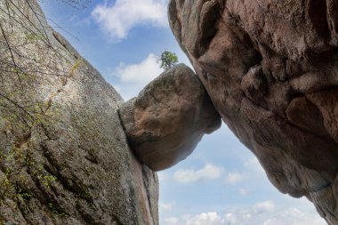 Natural arch with falling stone between two rocks. Lion's gate rock in Stolby Nature Reserve, Krasnoyarsk