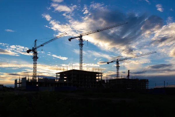 在黄昏的天空下 新建筑建筑工地上的起重机轮廓 工业背景 建筑业的概念 — 图库照片