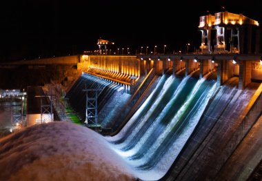 Spillway water to hydroelectric power station in Krasnoyarsk, Russia. Night industrial landscape with open locks on Krasnoyarsk Dam