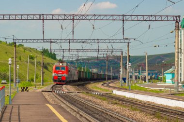 Krasnoyarsk, Rusya - 20 Haziran 2021: Trans-Sibirya Demiryolu 'nun demiryolu peronuna uzun bir yük treni geliyor. Rusya 'da demiryolu kargo taşımacılığı