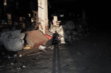 Çöp yığını üzerinde bir adamın gölgesi. Ekonomik arka plan kavramı, Dünya 'yı öldüren sınırsız tüketim kapasitesine sahip modern bir toplumun israfıdır. Geleceğin ekolojik mirası