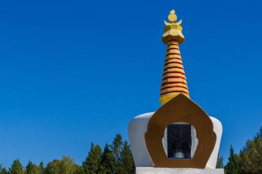 Mavi gökyüzü arka planına karşı Budist Aydınlanma Stupa heykelinin tepesinde. Sibirya 'ya Budist inancı.