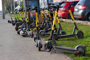 Krasnoyarsk, Rusya - 18 Eylül 2021: otomatik kiralama istasyonunda kiralık elektrikli scooterlar. Şehirdeki ekolojik taşıma kavramı