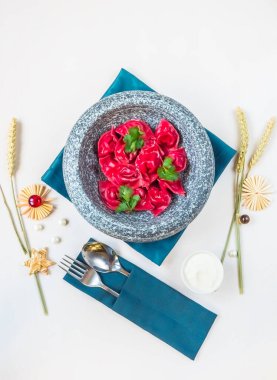Pancarlı ev yapımı ravioli ve tavşan etli kırmızı lahana. Gri taştan bir tabakta kırmızı hamur köftesi. Mermer tabakta köfteler. Üst görünüm