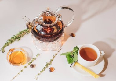 Bal ve taze nane yapraklarıyla sıcak ve bulanık bir arka planı olan cam çaydanlıkta sıcak yeşil çay. Kafede çay eşliğinde servis edildi. Su ısıtıcı.