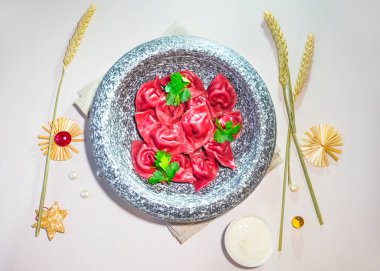 Pancarlı ev yapımı ravioli ve tavşan etli kırmızı lahana. Gri taştan bir tabakta kırmızı hamur köftesi. Mermer tabakta köfteler. Üst görünüm