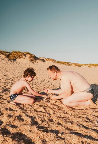 Bambino Suo Padre Stanno Giocando Con Conchiglie Sulla Spiaggia Famiglia — Foto Stock