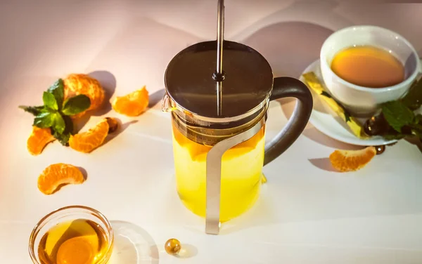 熱いお茶とティーポットメンデナリンミントハニー レストランの白いテーブルの上のタンジェリン茶 — ストック写真