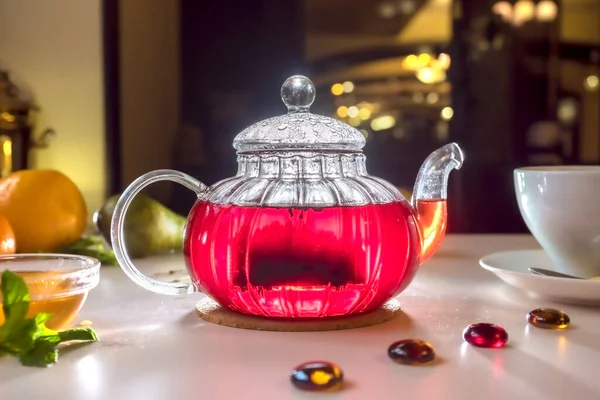 Red fruit tea with rose leaves. Foam tea with spices on the table in a cafe