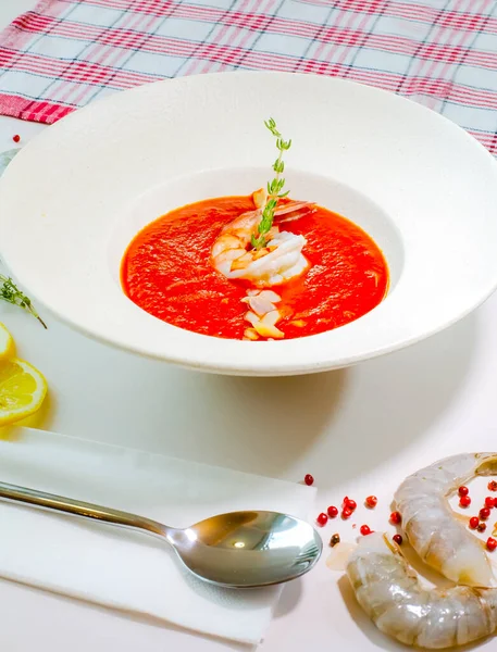Delicious cold tomato soup or gazpacho with shrimps in a white plate on a white table. Decor. Top view — Stock Image Delicious Cold Tomato Soup Gazpacho Shrimps White Plate White Table Royalty Free Stock Images