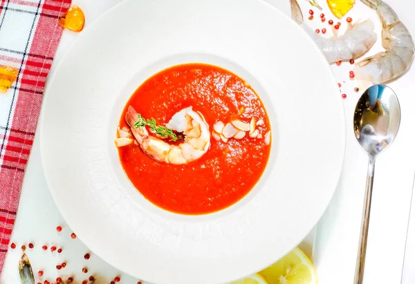 Delicious cold tomato soup or gazpacho with shrimps in a white plate on a white table. Decor. Top view — Stock Image Delicious Cold Tomato Soup Gazpacho Shrimps White Plate White Table Stock Picture