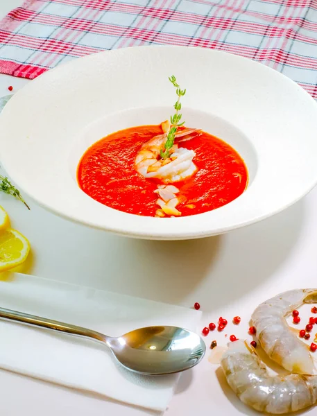 Delicious cold tomato soup or gazpacho with shrimps in a white plate on a white table. Decor. Top view — Stock Image Delicious Cold Tomato Soup Gazpacho Shrimps White Plate White Table Stock Photo