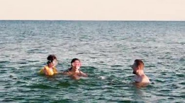 Olgun bir baba ve denizde oynayan çocuklar. Deniz kenarı konseptinde yaz tatili.
