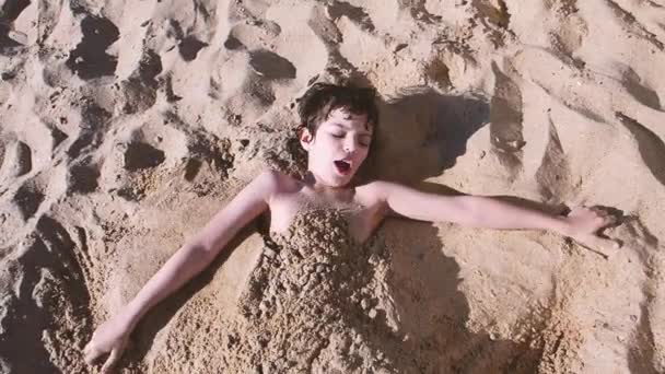 Little Boy Lies Beach Buried Sand Brunette Laughing Boy Buried — Stock Video