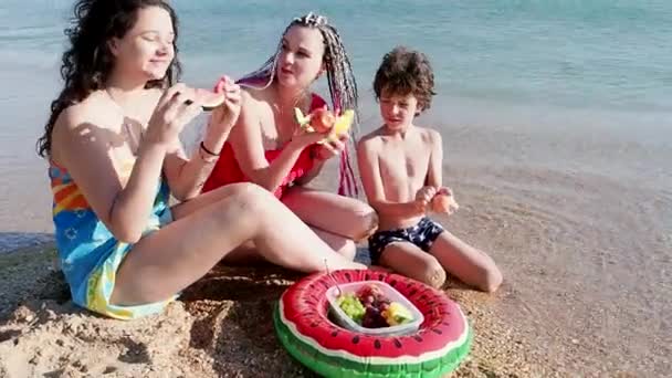 Familj Med Tre Ätande Frukter Vid Havet — Stockvideo