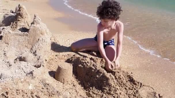 Μικρό Αγόρι Που Φτιάχνει Αμμόκαστρο Στην Παραλία — Αρχείο Βίντεο