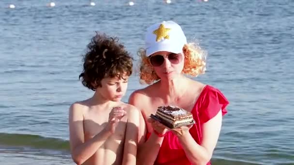Μητέρα Άσπρο Καπέλο Και Ξανθιά Περούκα Ταΐζει Τον Γιο Της — Αρχείο Βίντεο