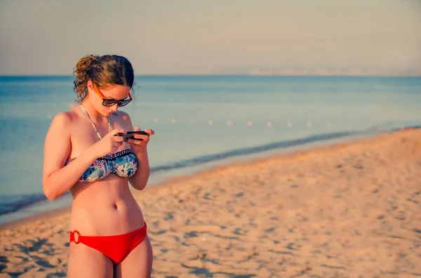 Hezká Dospívající Dívka Brunetka Pomocí Chytrého Telefonu Stojící Pláži Mořem — Stock fotografie