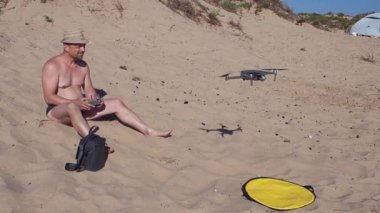 Adam kumsalda İHA kullanarak oturuyor. 