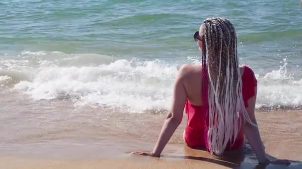 Eine Frau Mittleren Alters Mit Afrikanischen Zöpfen Sitzt Einem Sandstrand — Stockvideo