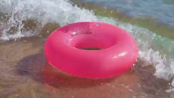 粉色海滩橡胶圈在海水和沙滩上滚动 — 图库视频影像