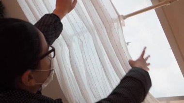 Yüzü maskeli genç esmer kız açık pencereyi 