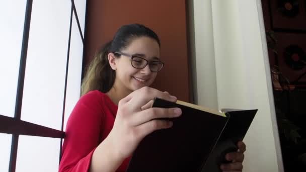 Joven Chica Morena Atractiva Leyendo Libro Sonriendo — Vídeo de stock
