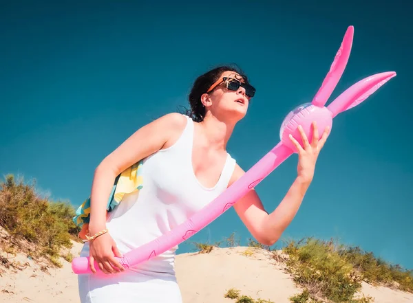 해변에서 휴가를 보내는 브루넷 여자는 야외에서 부풀어 오르는 분홍색 토끼와 — 스톡 사진