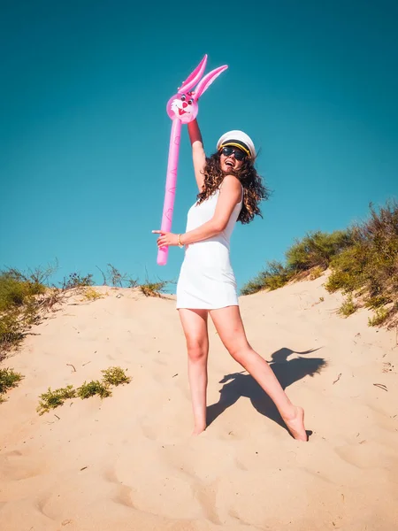 해변에서 모자를 여자는 야외에서 부풀어 오르는 분홍색 토끼와 재미있게 노는걸좋아 — 스톡 사진