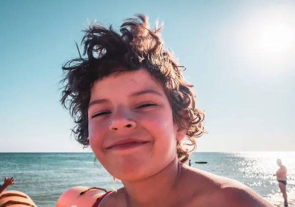 Glimlachende Baby Jongen Brunet Met Shaggy Hoort Oceaan Achtergrond — Stockfoto