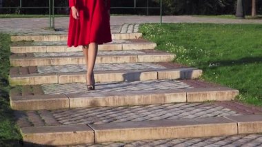 Topuklu giyen bir kadının merdivenlerden inerken çekilmiş görüntüleri.