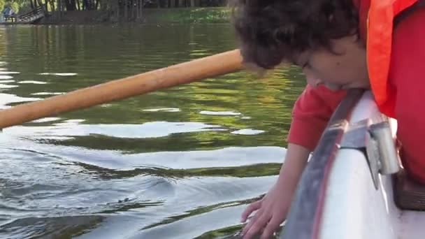 Niño Con Chaleco Salvavidas Tocando Agua Mientras Mueve Barco — Vídeo de stock