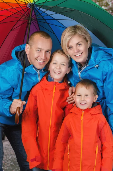 yağmurlu günde şemsiyesi altında mutlu ve renkli aile