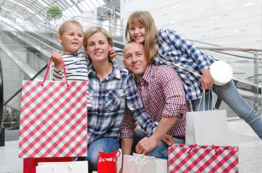 Alışveriş merkezinde alışveriş torbaları ile aile 