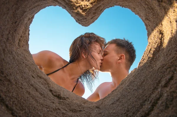 Kumsalda öpüşen çift.