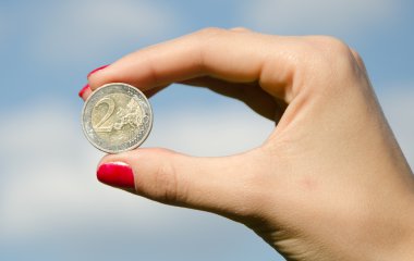 coin euroin the hands against the sky