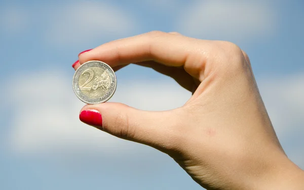 coin in the hands against the sky