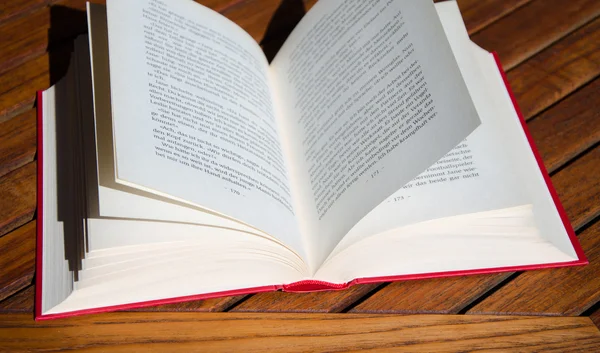 açık ahşap sandalye üzerinde kırmızı kitap