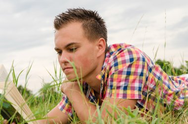 adam çimenlerde yalan bir kitap okuma