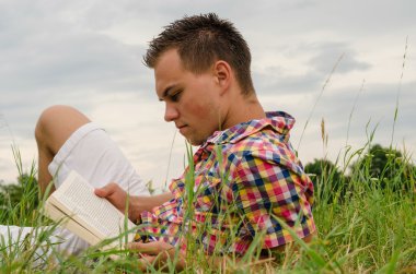 adam çimenlerde yalan bir kitap okuma