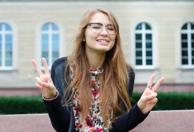 Güzel kadın el jest çifte zafer gösterilen